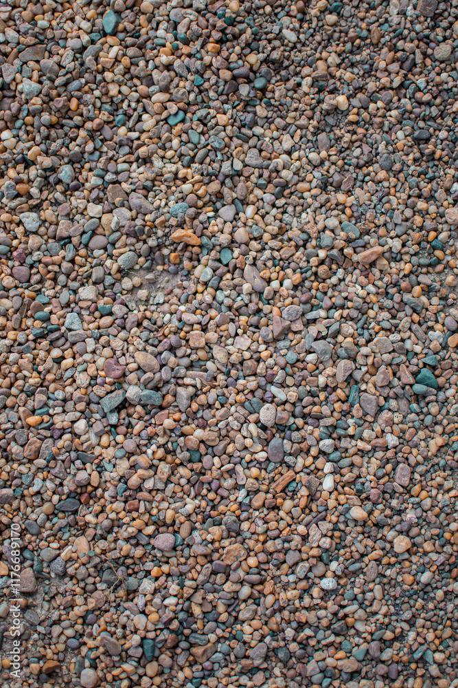 Stony beach on a sunny day. Background of different pebbles from above on the beach Stony beach on a sunny day. Background of different pebbles from above on the beach