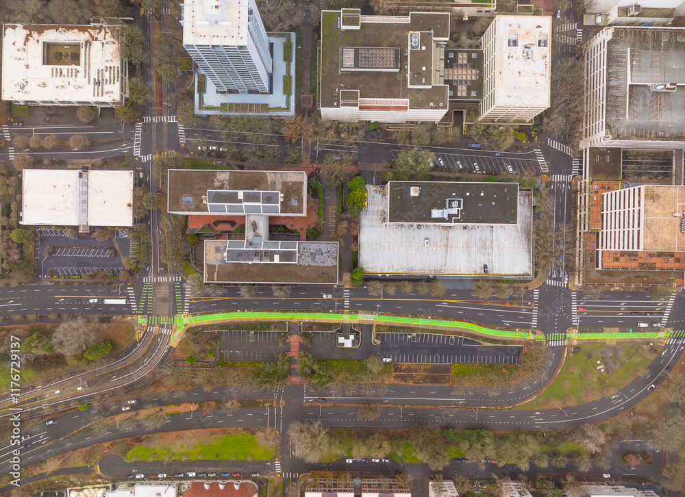 A city street view with a green crosswalk and a red arrow