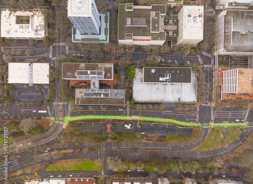 A city street view with a green crosswalk and a red arrow
