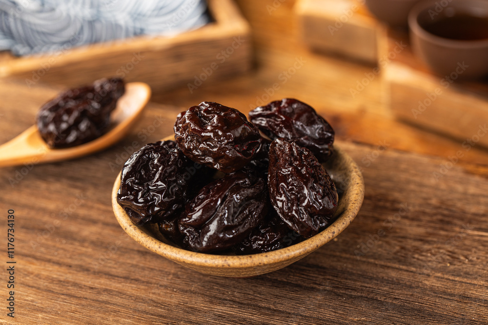 There are dried plums and dried sweet fruit preserves on the table There are dried plums and dried sweet fruit preserves on the table