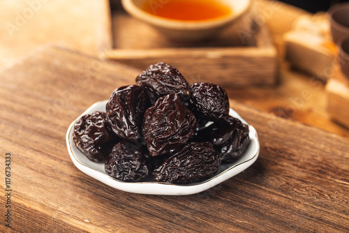 There are dried plums and dried sweet fruit preserves on the table