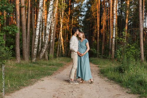 Affectionate man kissing woman at forest photo