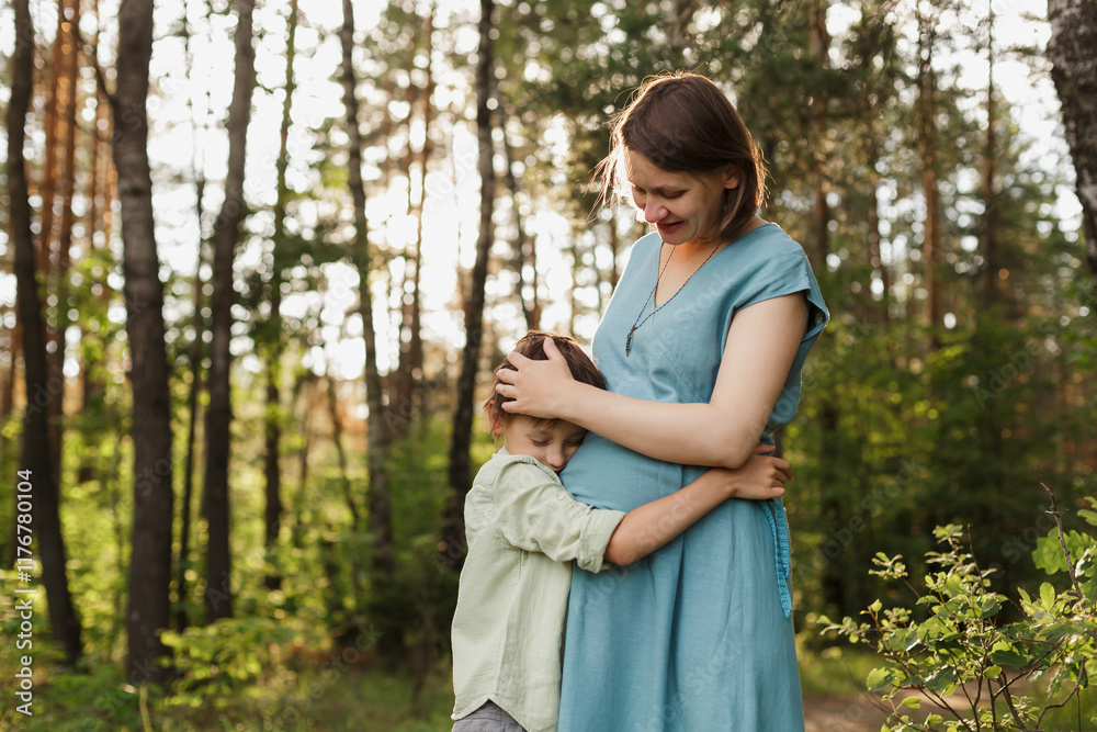 Son hugging pregnant mothers belly at meadow Son hugging pregnant mothers belly at meadow