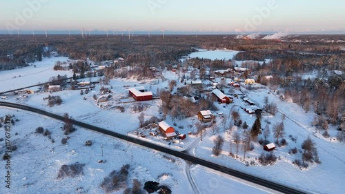 Snowy landscape covering a small village and wind farm photo