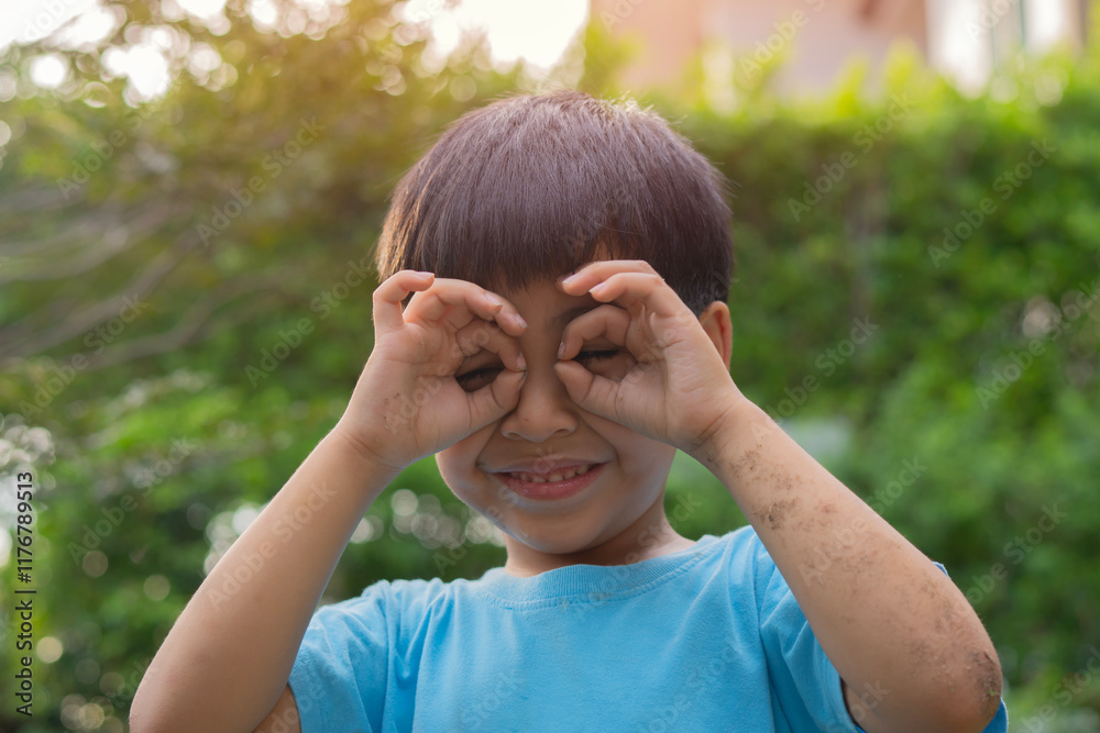 Asian boy with happy smiling and show sign hand on his face over nature background Asian boy with happy smiling and show sign hand on his face over nature background