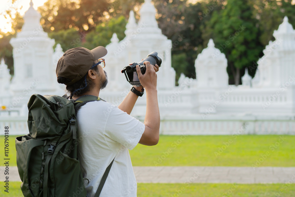 Young man taking pictures in the Suan Dok Temple, Chiang Mai, Thailand. Young man taking pictures in the Suan Dok Temple, Chiang Mai, Thailand.