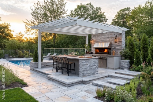 Modern backyard with outdoor kitchen, dining table, glass fence, white pergola, pizza oven, pool, and golden hour lighting creating a stylish design.
