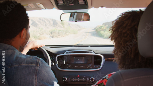 Obraz na plátně Rear View Of Young Couple On Road Trip Driving Rental Car Along Country Road