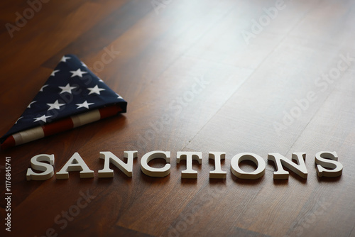 USA Flag with Sanctions Text on Wooden Floor Symbolizing Political and Economic Restrictions
