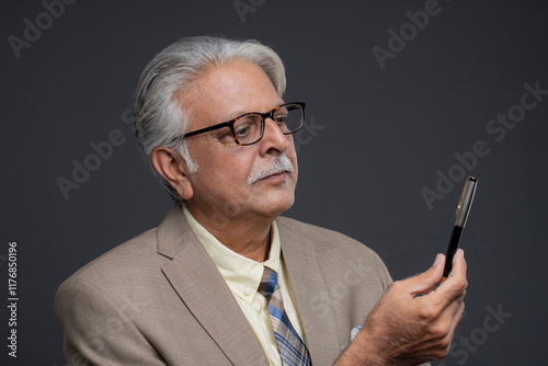 A Close-Up Of The General Director, Who Has A Serious Expression On His Face And Is Looking At The Pen That He Is Holding In His Hand.