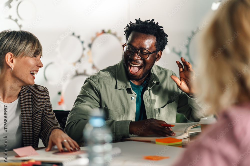 Enthusiastic coworkers laughing during a creative meeting Enthusiastic coworkers laughing during a creative meeting