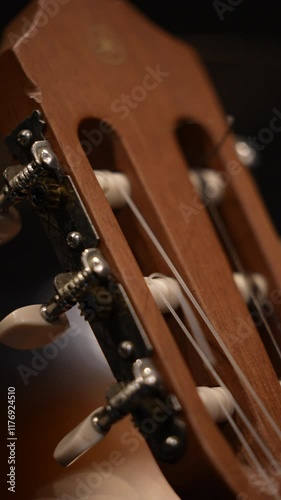 This close-up shows the details of the tuners and strings of a classical guitar. photo