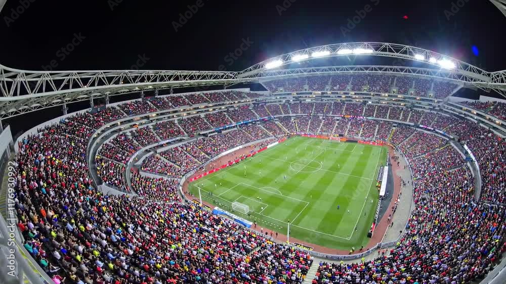 Exciting soccer match in a packed stadium under the night sky