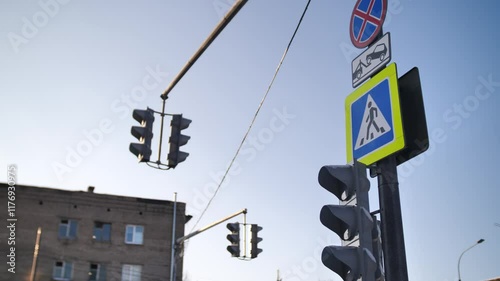 Urban traffic infrastructure with crosswalk sign and traffic lights against winter sky, for city planning presentations, road safety materials, transportation projects, municipal design layouts