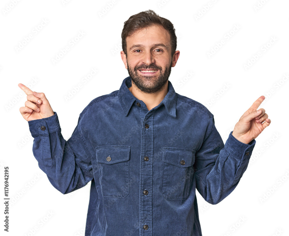 Fototapeta premium Studio portrait of young Hispanic male pointing to different copy spaces, choosing one of them, showing with finger.