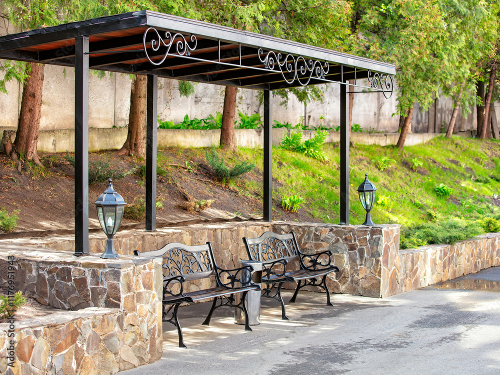 Elegant benches under a stylish canopy in a serene park setting during midday