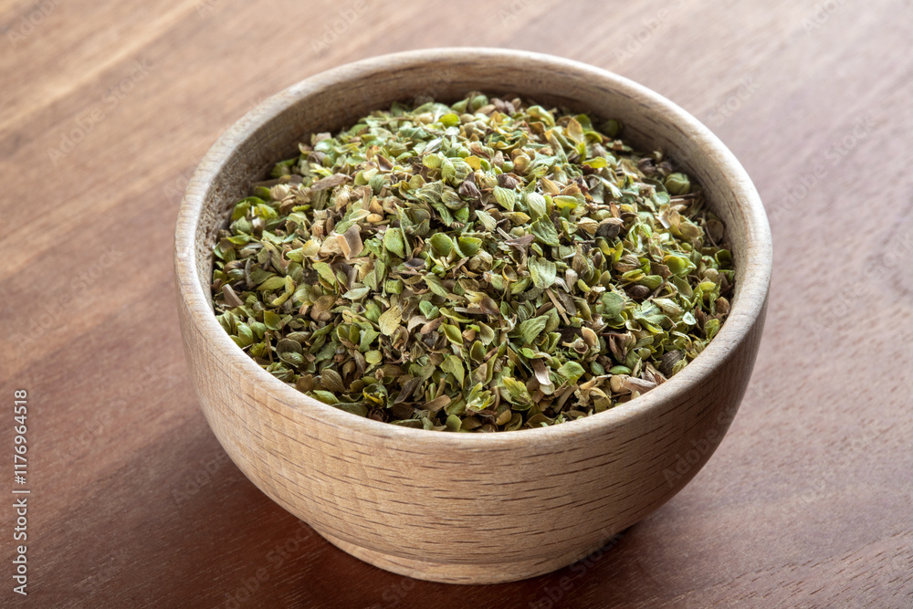 A bowl full of dried and ground organic mountain thyme on wooden table A bowl full of dried and ground organic mountain thyme on wooden table