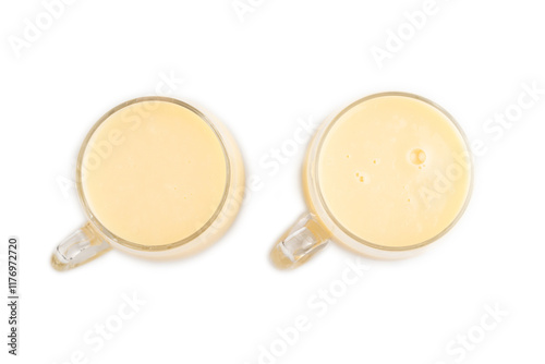 Organic non dairy banana and soy milk in glass isolated on white, top view, close up. photo