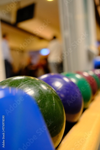 Bowlingkugeln liegen aneinandergereiht beim Abwurf, viel Tiefenunschärfe, Bunte Kugeln photo