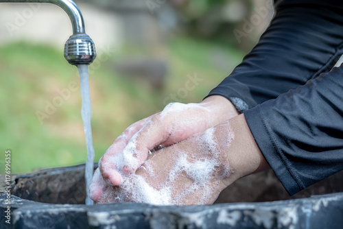 A girl is washing her hands in a sink in the park