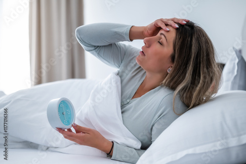 Φωτογραφία Woman is waking up in the morning and holding clock.