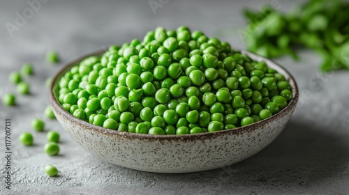 Fresh green peas piled in a rustic bowl on a simple wooden surface with soft ...