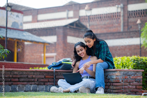 Female Young Students Pointing Their Fingers On the Laptop While Sitting On the Park Bench.