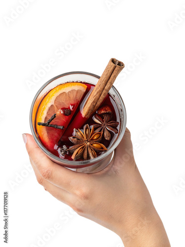 A glass of mulled wine with aromatic ingredients, held in a girl's hand, captured from a top view. photo