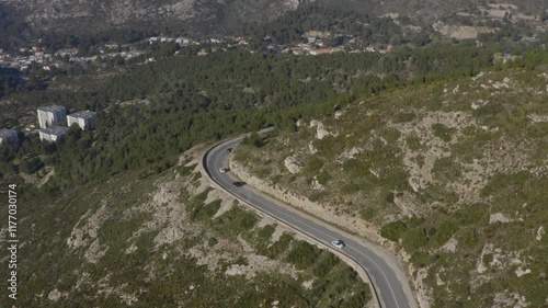 Aerial shot of cars driving on a bucolic road in the Calanques mountains around Marseille, France
