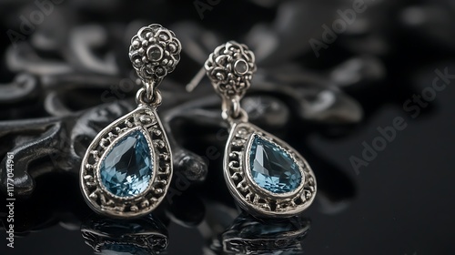 A pair of silver earrings with teardropshaped aquamarines photo