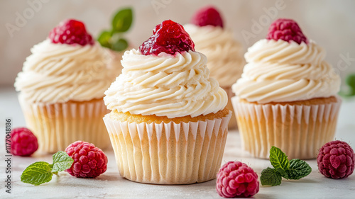 Beautiful Cupcakes With Cream Cheese Frosting and Raspberries Displayed Elegantly on a Light Surface