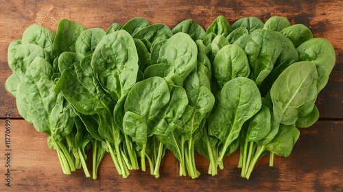 Freshly harvested spinach placed on a wooden cutting board indoors during bri...