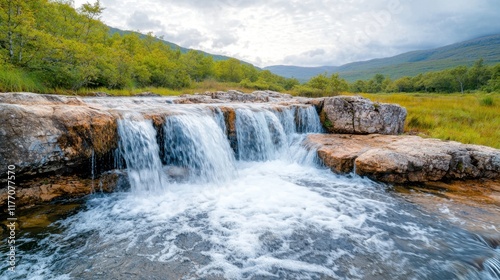The waterfall is a breathtaking natural wonder cascading down a series of rocky cliffs, surrounded by lush greenery and the soothing sound of rushing water.