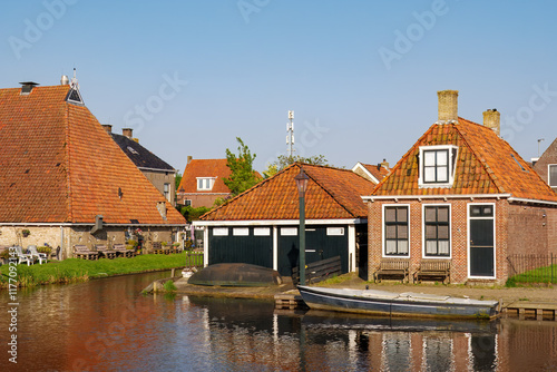 House with boathouse along Zijlroede canal in old town of Hindeloopen, Friesland, Netherlands