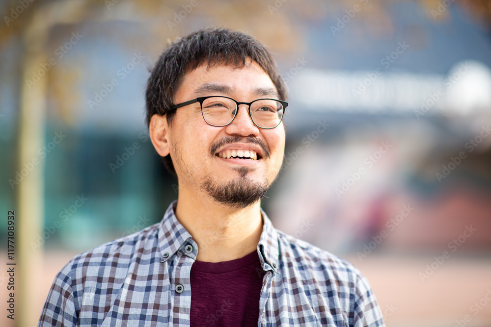 Close-up portrait of a happy Asian man looking up outdoors Close-up portrait of a happy Asian man looking up outdoors