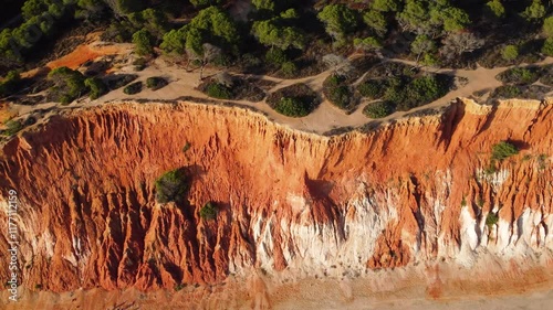 Aerial landscape of South of Portugal, Algarve Region. Orange cliffs. Sany beaches. Drone backwards and camera tilt up. Small urbanisations. Campings. Famous travel destination. photo