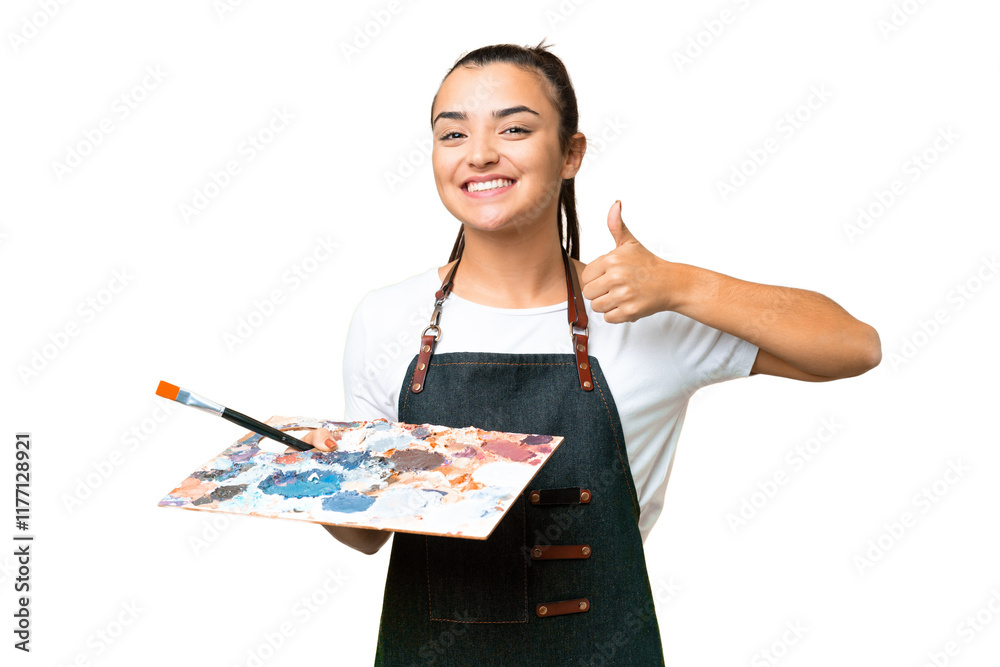 Young artist woman holding a palette over isolated chroma key background giving a thumbs up gesture Young artist woman holding a palette over isolated chroma key background giving a thumbs up gesture