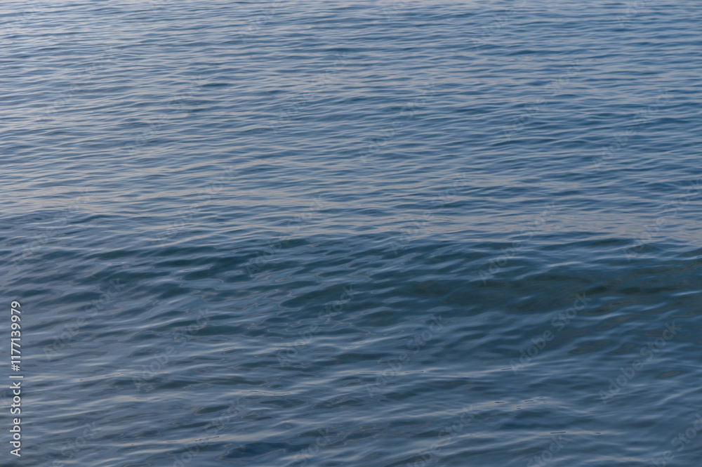 Gentle waves dance across the serene blue waters at sunset on a peaceful coastal evening Gentle waves dance across the serene blue waters at sunset on a peaceful coastal evening