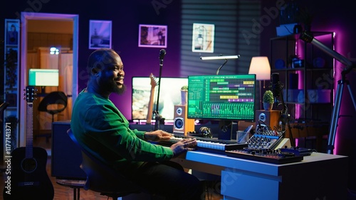 Musician playing piano keyboard and recording tracks for mix and master session, using digital software on pc to create new songs. Sound producer composing music with midi controller tool. Camera B.