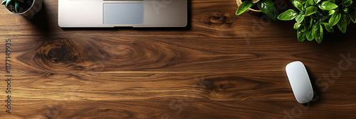 Modern laptop resting dark walnut wooden desk surrounded few office essential like potted plant wireless mouse natural wood texture of desk brings warmth sleek techfocused scene offering perfect blend