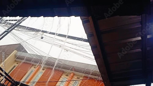 Heavy Rain Drops Falling From Roof.Rain flows from a house roof into a gutter during rain. close-up