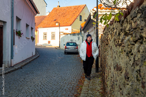 Obraz na płótnie A plus-size woman strolling through the streets of a small European town. w salonie