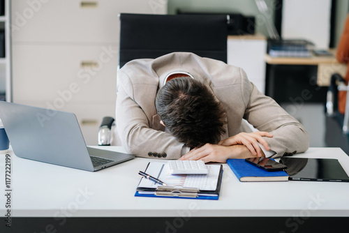 Young stressed caucasian businessman working in the office. Businessman thinking too much work concept in the office. photo