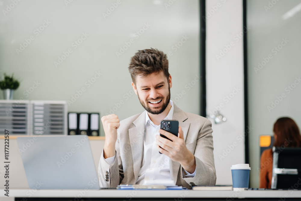 Successful business man, excited young man Keeping up arms and showing positive emotions, happy working in modern office on computer. Successful business man, excited young man Keeping up arms and showing positive emotions, happy working in modern office on computer.