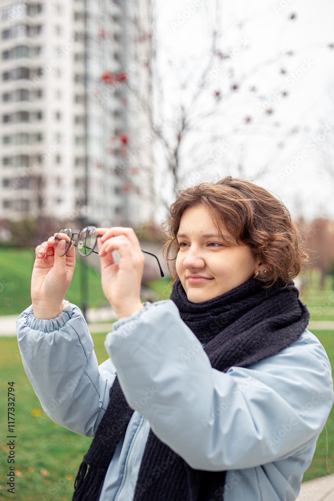 Portrait of a beautiful young woman holding glasses in her hand in the city. Portrait of a beautiful young woman holding glasses in her hand in the city.