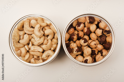 Cashews and hazelnuts in a jar on a white background.