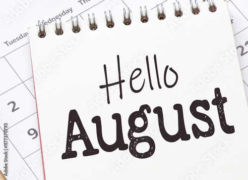 HELLO AUGUST words in notebook on calendar.