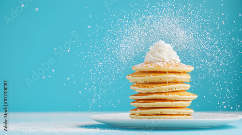 Delicious pancakes stacked high with whipped cream and powdered sugar