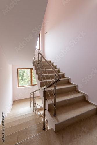 Modern stair case between floors. Stairs with metallic rail in modern building