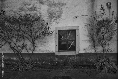 A strange old poor square window on an old peeling wall. B/W